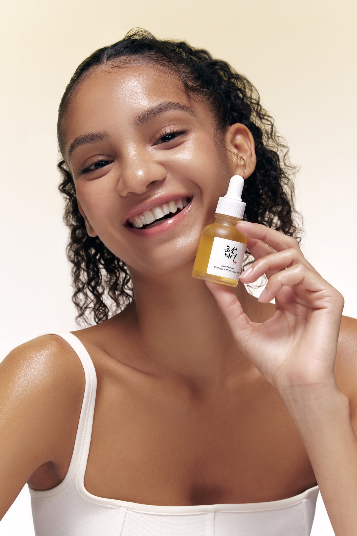 A model holding Beauty of Joseon Glow Propolis Serum in her hand.