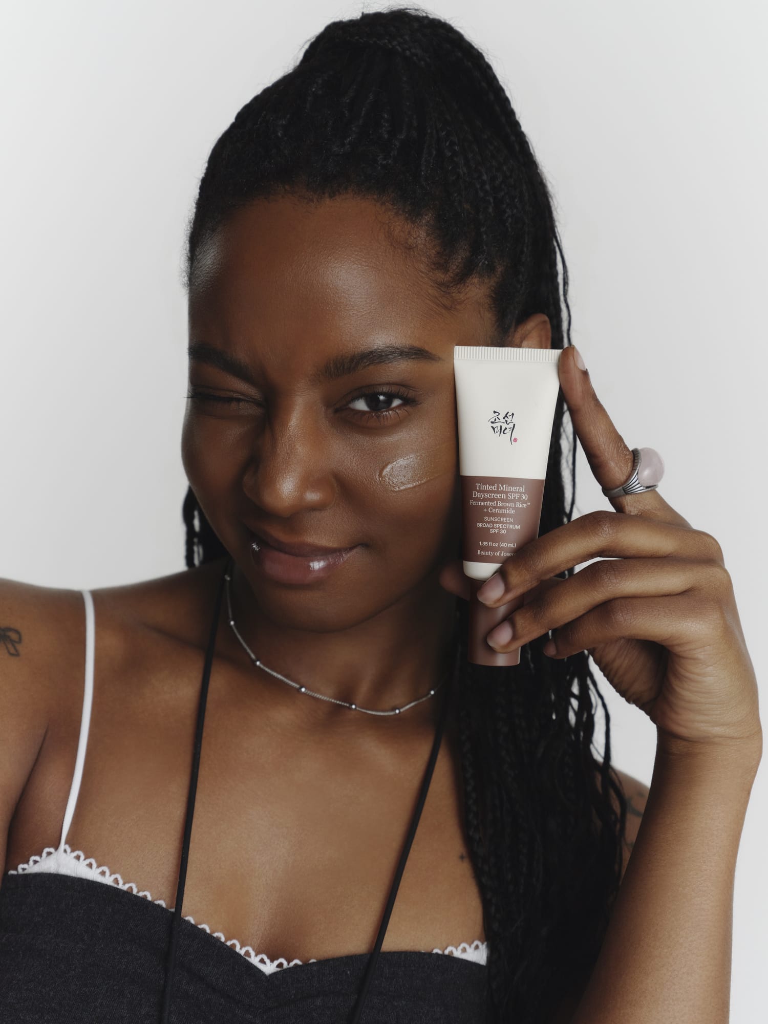 A model holding a Tinted Mineral Dayscreen product.
