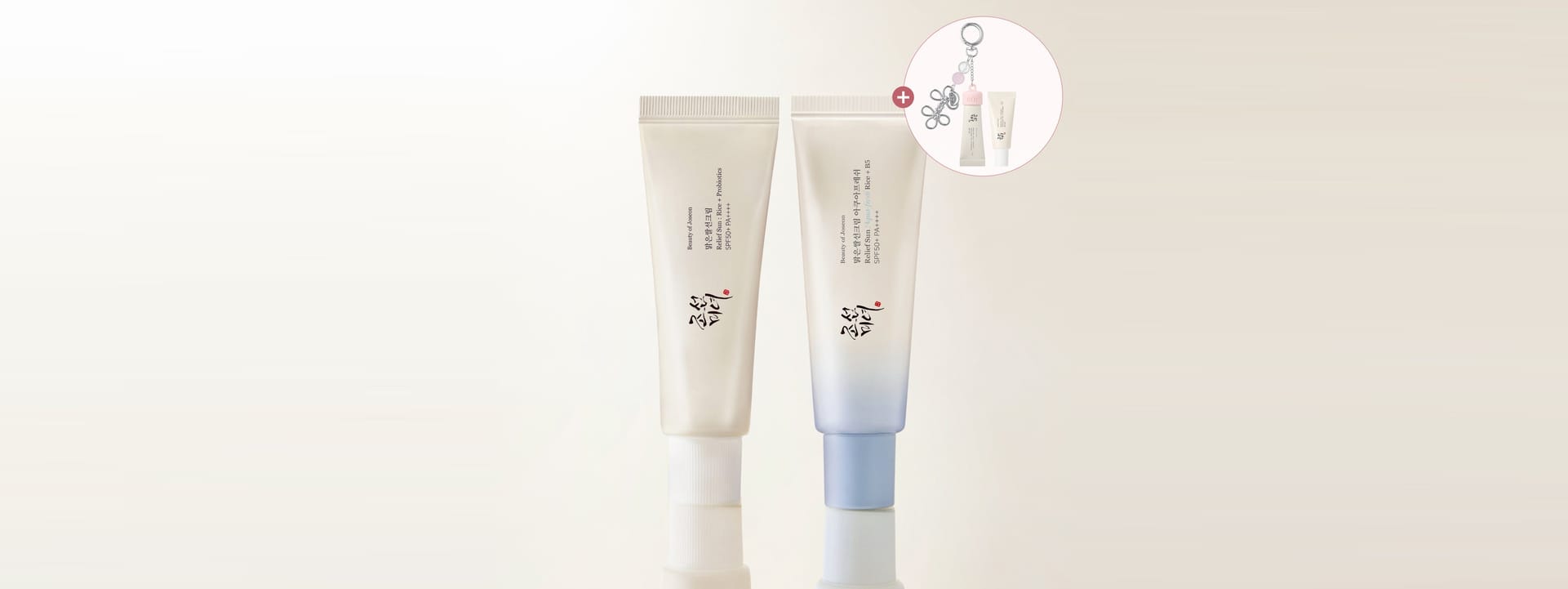 Two cosmetic tubes standing upright on a reflective surface against a light beige background, with a small circular inset showing additional product contents.