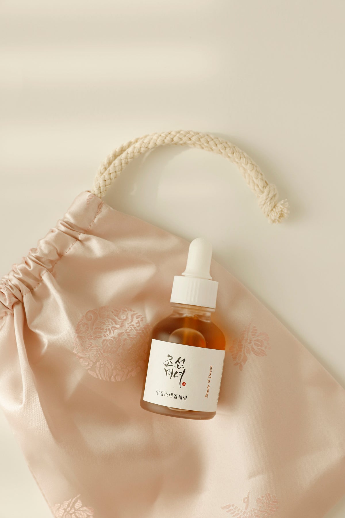 a small bottle of liquid on a pink bag