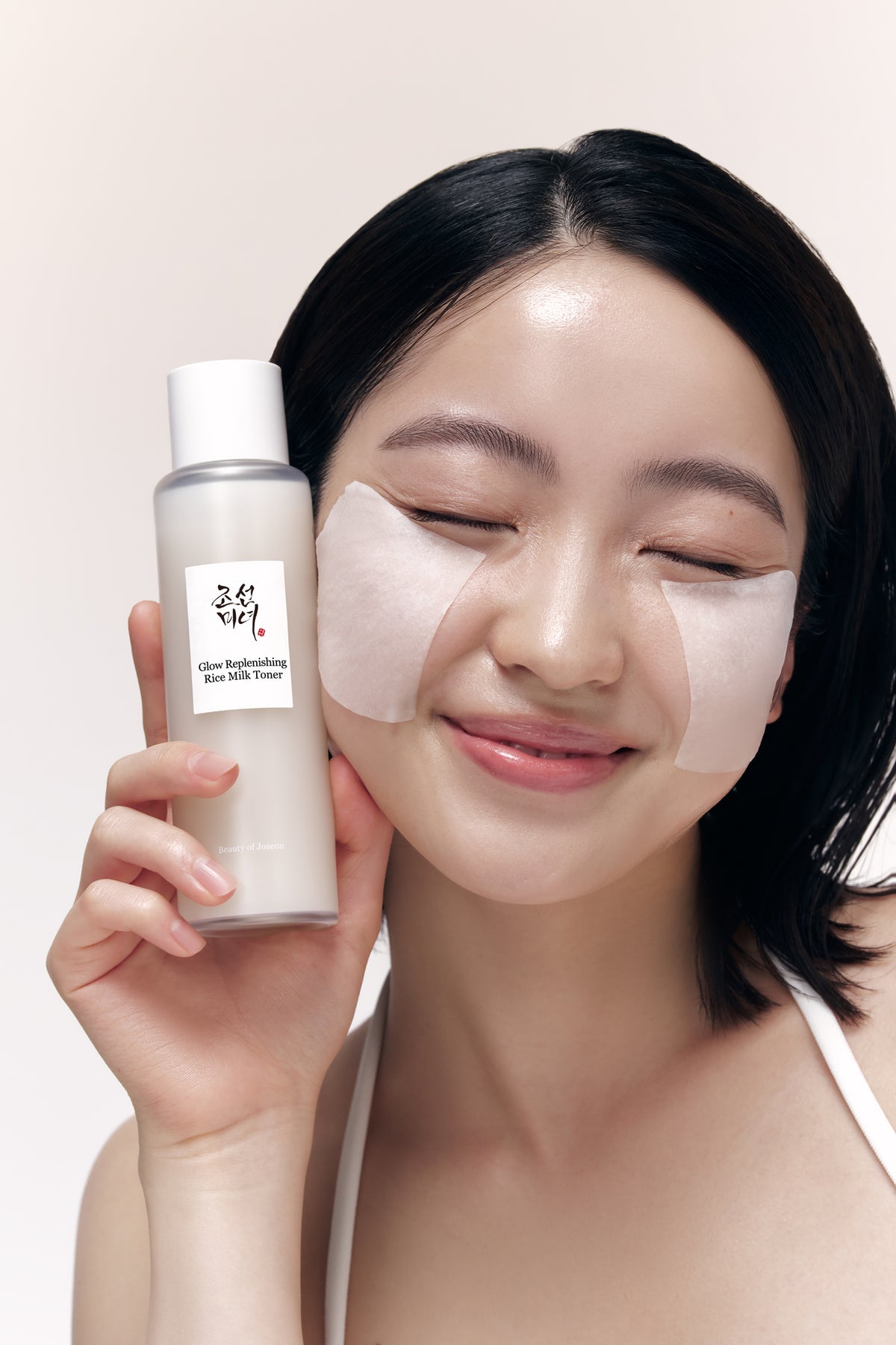 A model holding Beauty of Joseon Glow Rice Milk Toner in her hand.